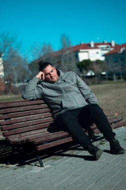 Adam bir köşede dinleniyor, bir bankta oturuyor, şehir dışı yaşam tarzının tadını çıkarıyor.