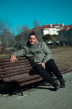 Siyah saçlı bir adam bankta oturan bir topuz içinde geri çekildi.