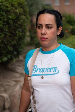 Şehir sabahında bir kadın dalgın bir ifadeyle dışarıda yürüyor.