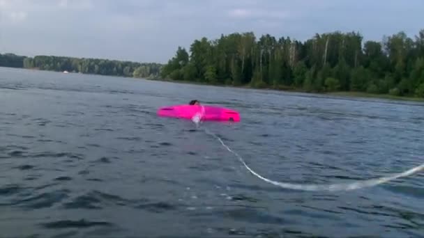 Девушка-вейкбордер плавает в пруду с доской — стоковое видео
