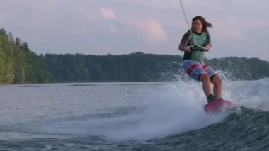 Wakeboard, yaz gün batımı göl kenarında kız