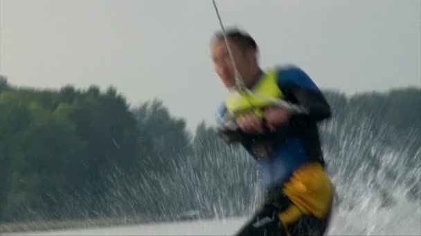 Primer plano de wakeboarder hombre montando la ola y aplastar en el agua — Vídeo de stock