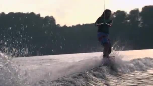 Flickan hoppar vågor på wakeboard, sommar solnedgång — Stockvideo