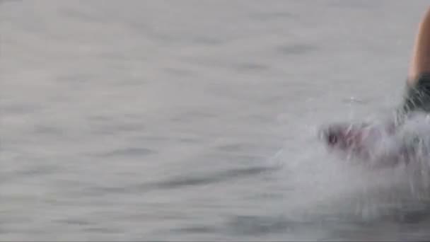 Wakeboarder jambes bottes et planche sur l'eau, gros plan — Video