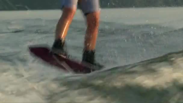 Nära upp skott wakeboarder stövlar och styrelsen på vatten — Stockvideo