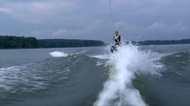 Islak elbise darbeye suda bir hile yapmak çalışırken Wakeboarder adam