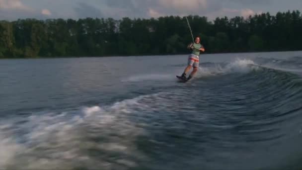 Smajlík dívka na wakeboard tvorby probuzení k probuzení trik a na podzim ve vodě — Stock video