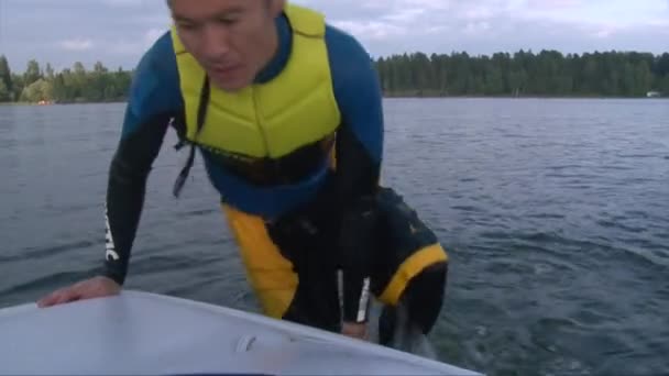 Close up shot man in wet diving suit climbs on boat — Stock Video