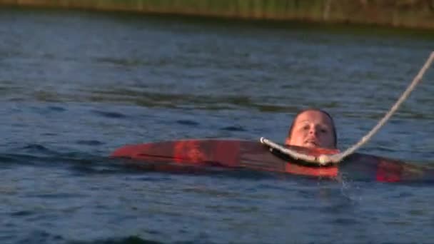 Bliska strzał piękna szczupła dziewczyna start obudzić pokład z wody jeziora — Wideo stockowe