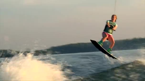Adolescente menina no wakeboard fazer wake para acordar ricky truque — Vídeo de Stock