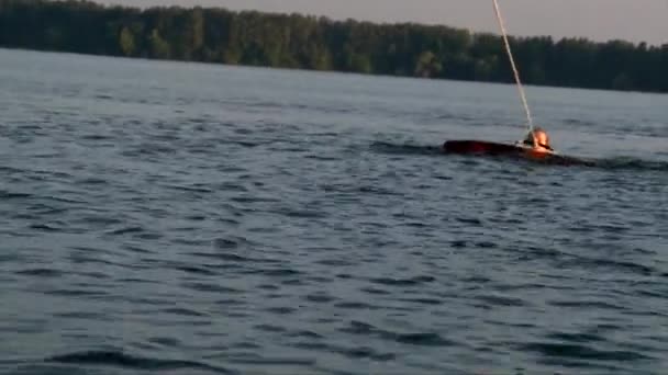 Рыжая голова бодрствующая девушка начинает ездить от озера воды, закат неба — стоковое видео