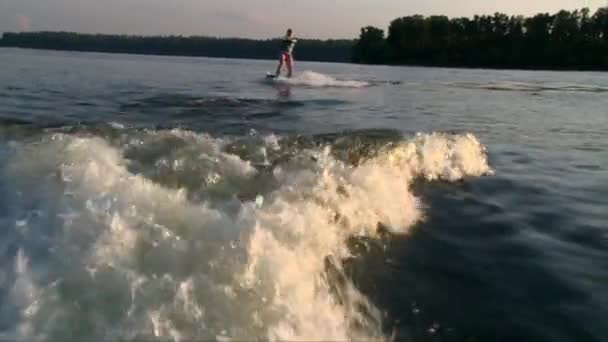 Рыжая девушка начинает садиться на воду из озера — стоковое видео