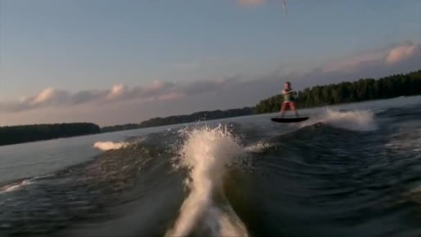 Mooi slank meisje het maken van wake to wake truc en crash in water — Stockvideo