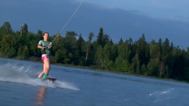 Красивая девушка на вейкборде, летний закат на пруду — стоковое видео