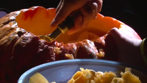 Verwijderen van zaden en het vlees van een pompoen op scull en vleermuis op achtergrond — Stockvideo