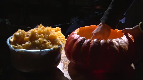 Scooping meat from pumpkin and shake it out — Stock Video