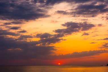 Denizde gün doğumunda dramatik bir gökyüzü. Duvar kağıdı için harika bir atmosferik arka plan. Suyun üstünde fırtınalı bulutlar. Güneş ufukta belirdi. Sozopol Körfezi 'nin yaz manzarası. ılık renkli bir eğilim