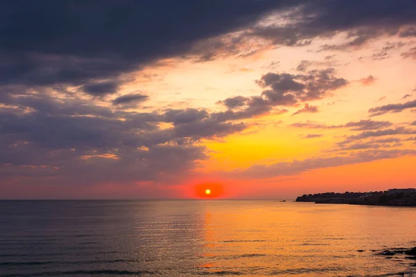 Denizde gün doğumunda dramatik bir gökyüzü. Duvar kağıdı için harika bir atmosferik arka plan. Suyun üstünde fırtınalı bulutlar. Güneş ufukta belirdi. Sozopol Körfezi 'nin yaz manzarası. ılık renkli bir eğilim