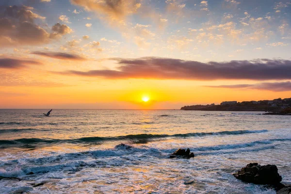 Güneşin doğuşunda eski şehir plajı. Sabah ışığında, İspanya sahillerinin güzel manzarası. Turuncu gökyüzü ve deniz üzerinde bulutlar. resim gibi tatil sezonu ya da yoga ya da fotoğrafçılık için rahatlama konsepti