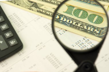 Gelir hesaplama konsepti. Büyüteç 100 dolar yakınlaştırma payını arttırıyor. Sayı arkaplanı hesabı