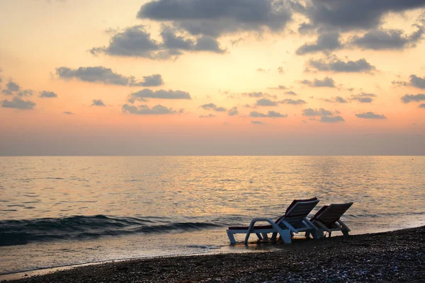 Gün batımında deniz kenarında şezlonglar. Romantik bir ruh hali. Yaz zamanı konsepti