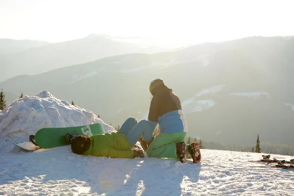 Skier Memeriksa Kaki Snowboarder Yang Terletak Atas Salju Setelah Jatuh Stok Lukisan  