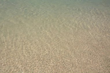 Parlak mavi deniz suyu arka planda dalgalanır, dalgalar ve parlar. Elafonisi plajı, Girit Adası simgesi, Yunanistan