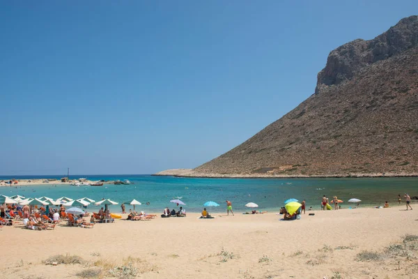 CRETE, STAVROS - 07 Ağustos 2018: Yunanistan 'ın Girit adasındaki Stavros plajı. Turistler dinlenir, yüzer ve berrak mavi sularda yıkanır.