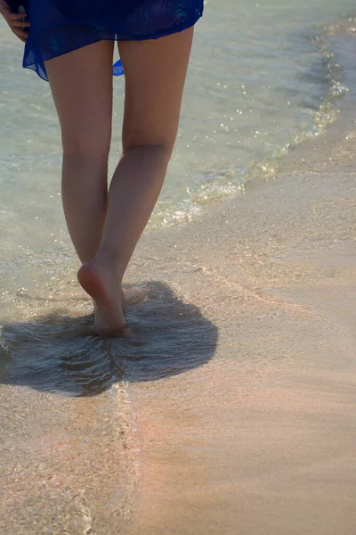 海岸沿いを歩く女性の裸の足 ピンクの砂ときれいな水 エラフォニシビーチ クレタ島 — ストック写真