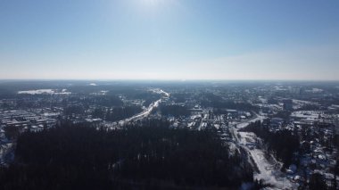 Kış manzarası karla kaplı. Kentte tarlalar ve yollar var. Hava aracı fotoğrafı..