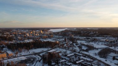 Kış şehrinde güzel bir günbatımının insansız hava aracı çekimi.