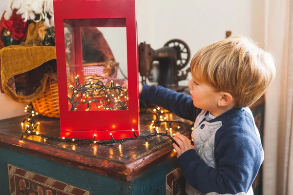 Lindo niño con luces de Navidad en casa — Foto de Stock