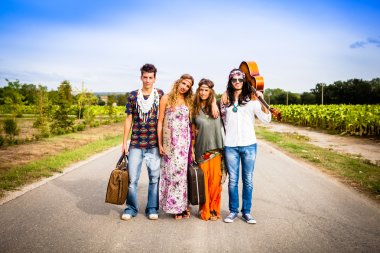 Four hippie friends walking on countryside clipart