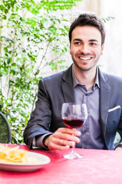 Yakışıklı delikanlı kadeh şarap ile