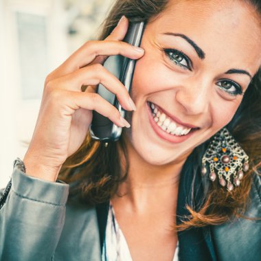 Güzel bir kadın cep telefonuyla konuşuyor.