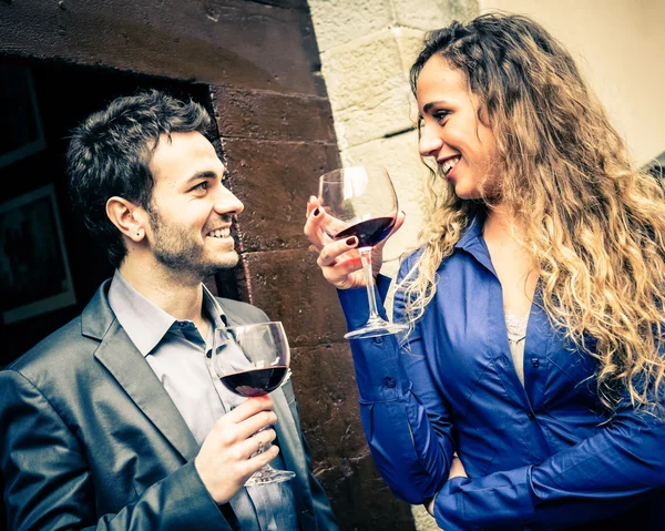 Pareja sonriente sosteniendo vasos con vino — Foto de Stock