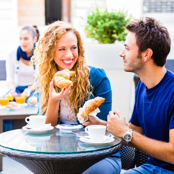 Par dricka kaffe och äta croissanter — Stockfoto