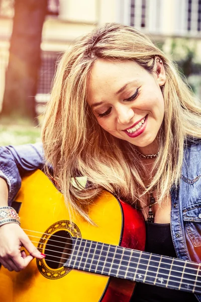 Donna bionda che suona la chitarra nel parco — Foto Stock