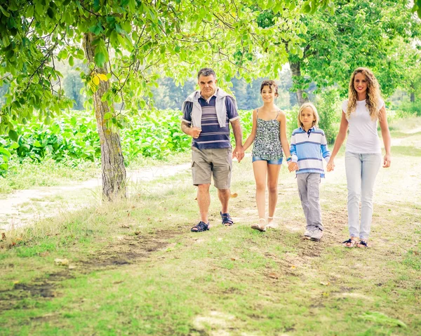 Familia caminando por el parque — Foto de Stock