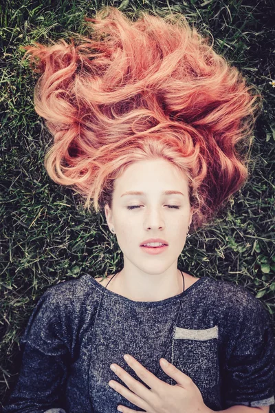 Mujer con el pelo largo acostada en la hierba — Foto de Stock