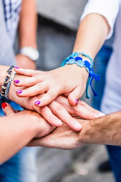 Groep vrienden hand in hand in stapel — Stockfoto