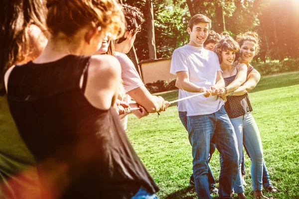 Happy friends pulling rope together