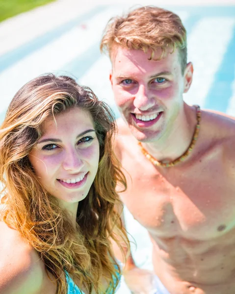 Pareja joven junto a la piscina — Foto de Stock