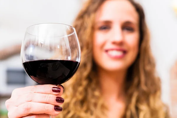 Mujer sonriente sosteniendo un vaso de vino — Foto de Stock