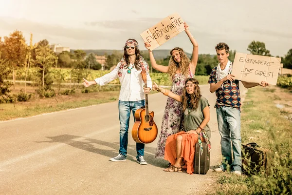 Hippies carona na estrada com cartazes — Fotografia de Stock