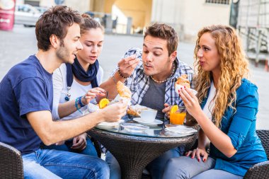 arkadaşlar kruvasan bardak kahve ile yemek 