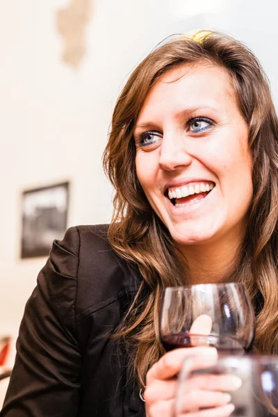 Mujer sonriente sosteniendo un vaso de vino — Foto de Stock