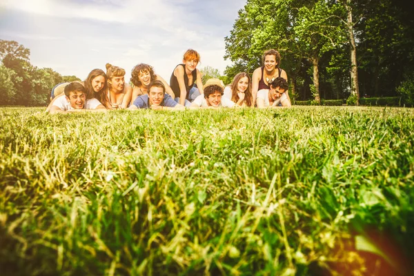 Amigos acostados en la hierba en el parque — Foto de Stock