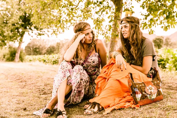 Gyönyörű hippi barátnők ül a fűben — Stock Fotó