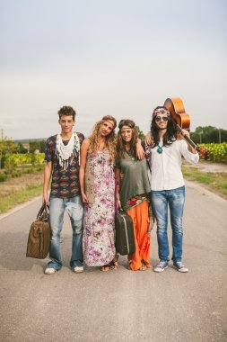 Group of hippie friends walking on countryside clipart